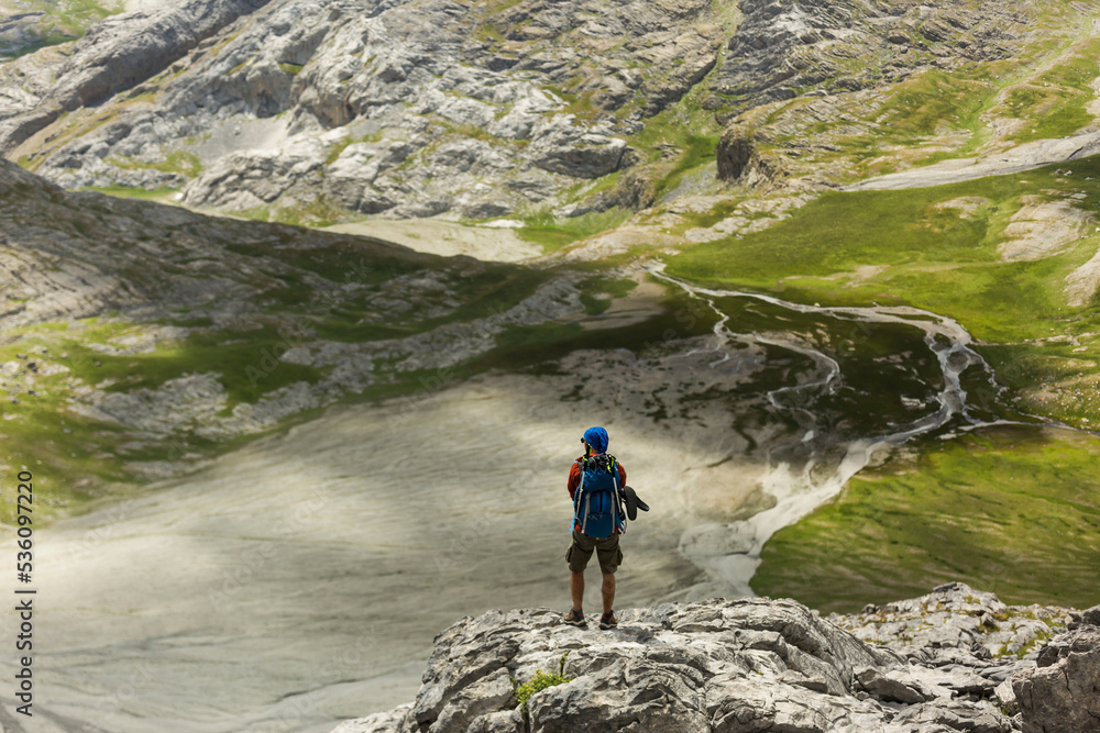 Unrecognizable traveler admiring river in mountains Unrecognizable traveler admiring river in mountains