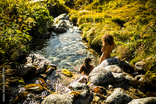 Women taking bath in mountain river photo