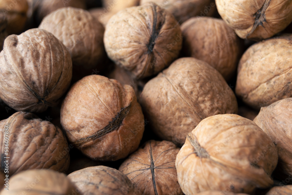 Heap of raw walnuts close-up as background. Heap of raw walnuts close-up as background.