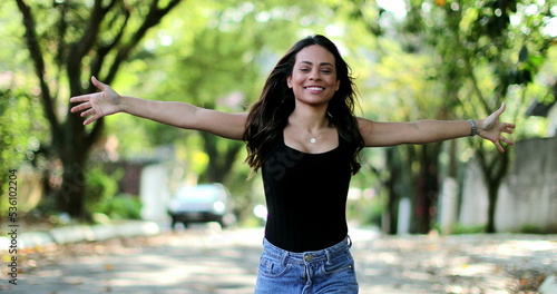 Excited Brazilian woman celebrating jumping with joy and happiness