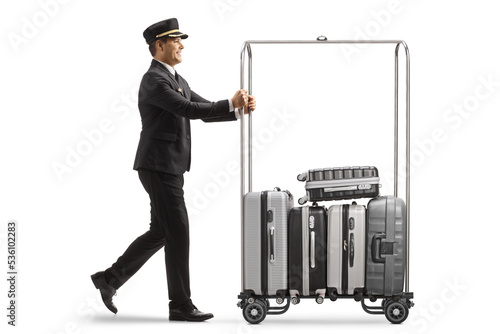 Fotografie Bellboy pushing suitcases on a hotel luggage cart