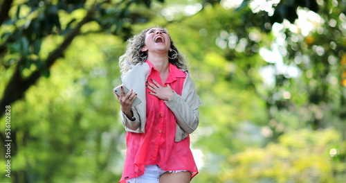 Fototapeta Naklejka Na Ścianę i Meble -  Ecstatic woman receiving confirmation message on cellphone jumping with joy and celebration