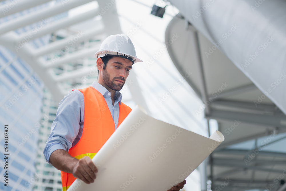 Man engineer standing on construction site. Engineer working on outdoor project Man engineer standing on construction site. Engineer working on outdoor project