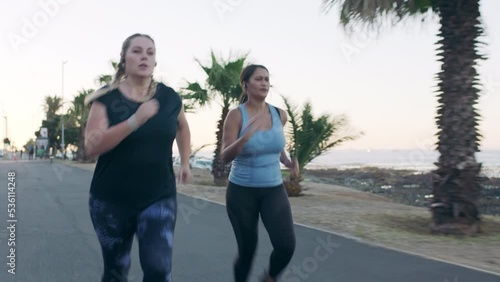 Women are running in the street, exercise, fitness and motivation for health and wellness. Diverse runners, serious, and cardio workout in urban scene for weight loss and stamina or endurance.