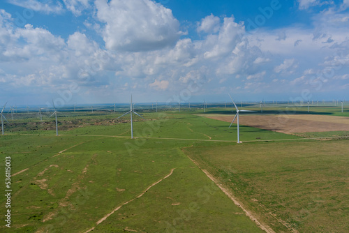 A row of windmill renewable energy turbines on a wind farm generate electricity in the Texas state of the United States.