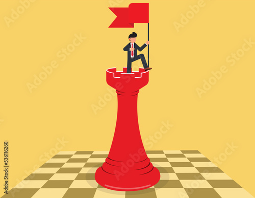 Successful business strategy. businessman standing on chess and holding a flag.