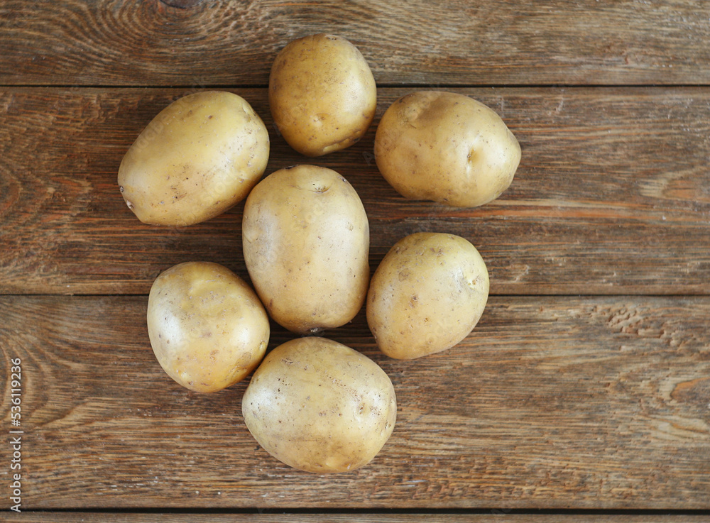 Washed potatoes lie on a wooden table. View from above. Farm food concept Washed potatoes lie on a wooden table. View from above. Farm food concept