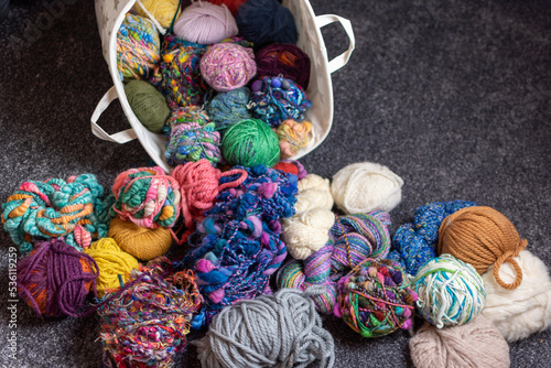 yarn stash - a pile and basket of balls of wool for knitting and crochet in  a crafters living room 