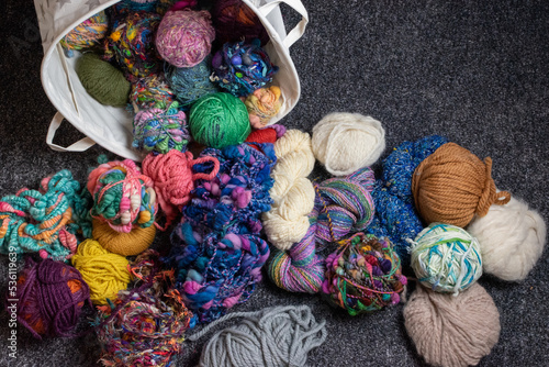 yarn stash - a pile and basket of balls of wool for knitting and crochet in  a crafters living room 