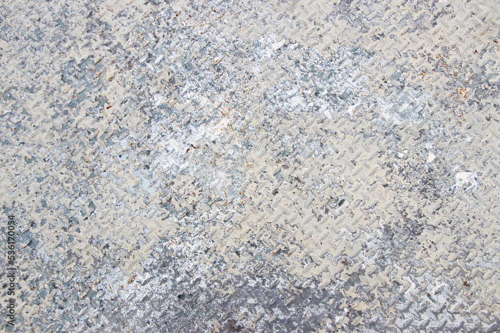 Old diamond pattern steel floor partial cover by cracked white paint and rust. Old diamond pattern steel floor partial cover by cracked white paint and rust.