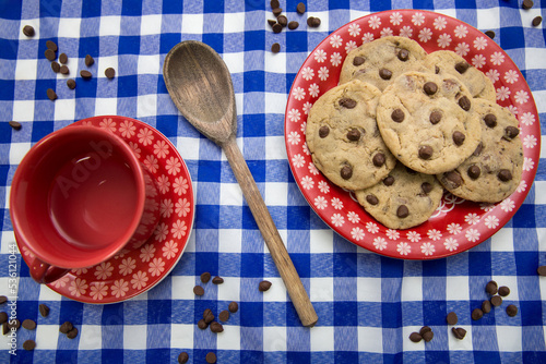 chocolate chips cookies on a plate and a cup of tea table
