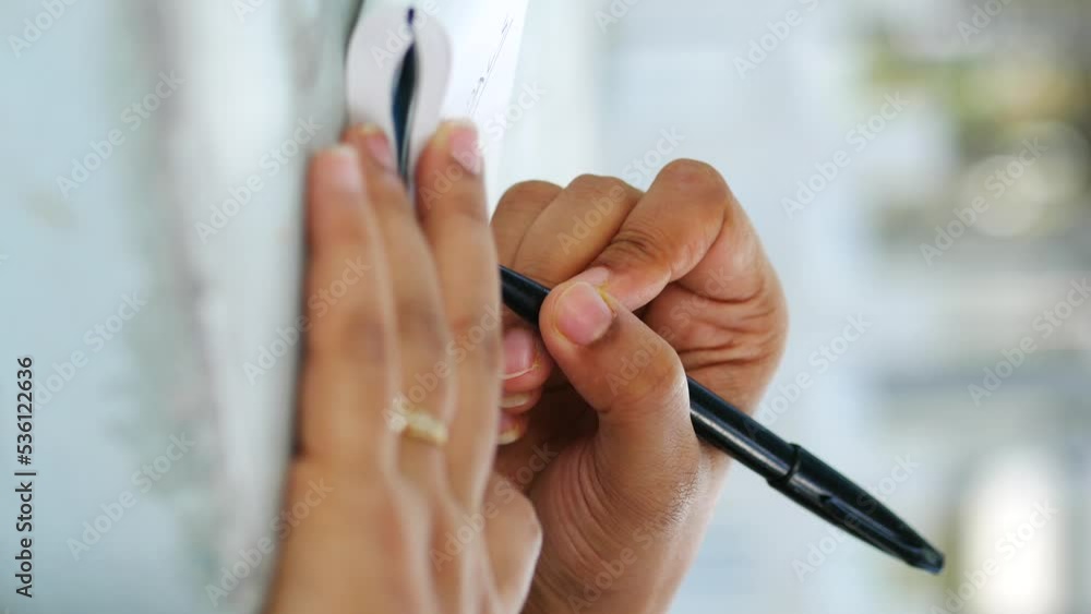 Close up of women hand writing on notepad. Close up of women hand writing on notepad.