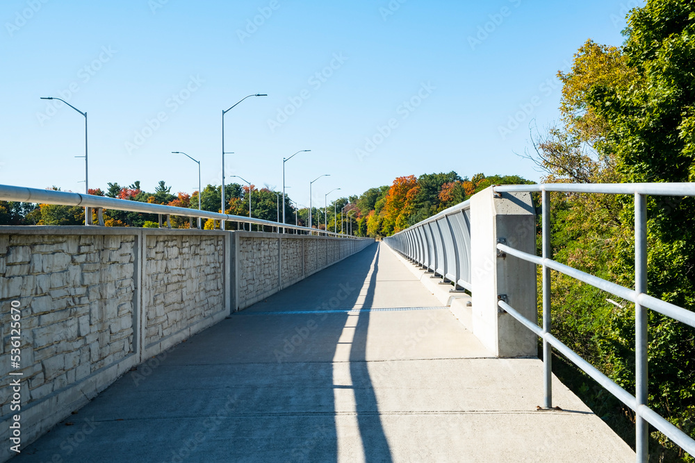 Walkway on a Bridge Over Credit River Ontario With Colorful Fall Foliage Surrounding It