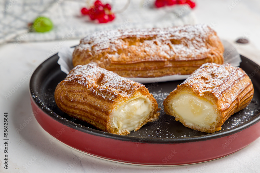 vanilla Eclair on a white plate on marble table vanilla Eclair on a white plate on marble table