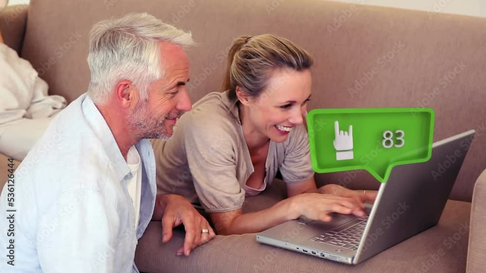 Animation of social media icon with growing number over caucasian couple using laptop Animation of social media icon with growing number over caucasian couple using laptop