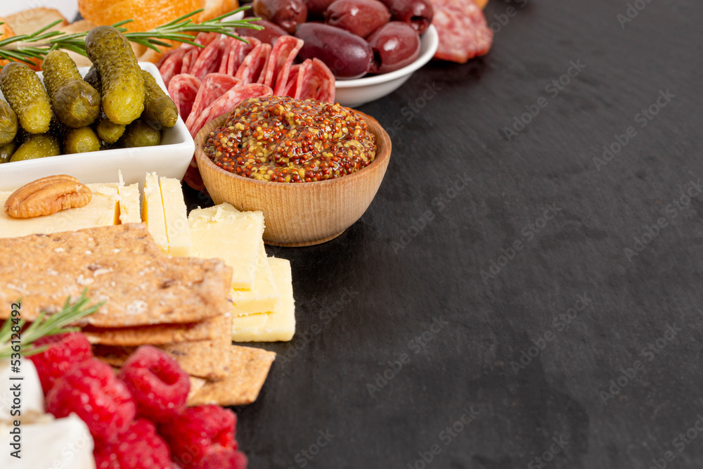 Meat and Cheese Charcuterie Board on a Black Slate Slab Meat and Cheese Charcuterie Board on a Black Slate Slab