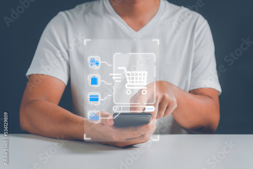 A man paying and shopping online with smartphone application at home. Digital money transfer, banking and e commerce concept.Mobile payment with wallet app technology.