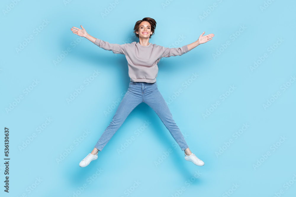 Fototapeta premium Full body photo of short hairdo young lady jump wear shirt jeans shoes isolated on blue color background