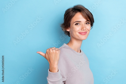 Photo of pretty sweet positive lady arm thumb index direct empty space advertises good choice cool job isolated on blue color background
