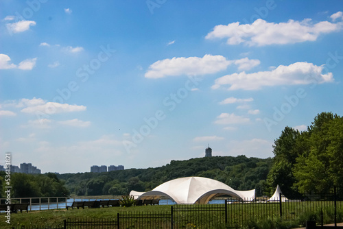 Recreation area for vacationers on the river with benches and a white dome in the midst of gum trees