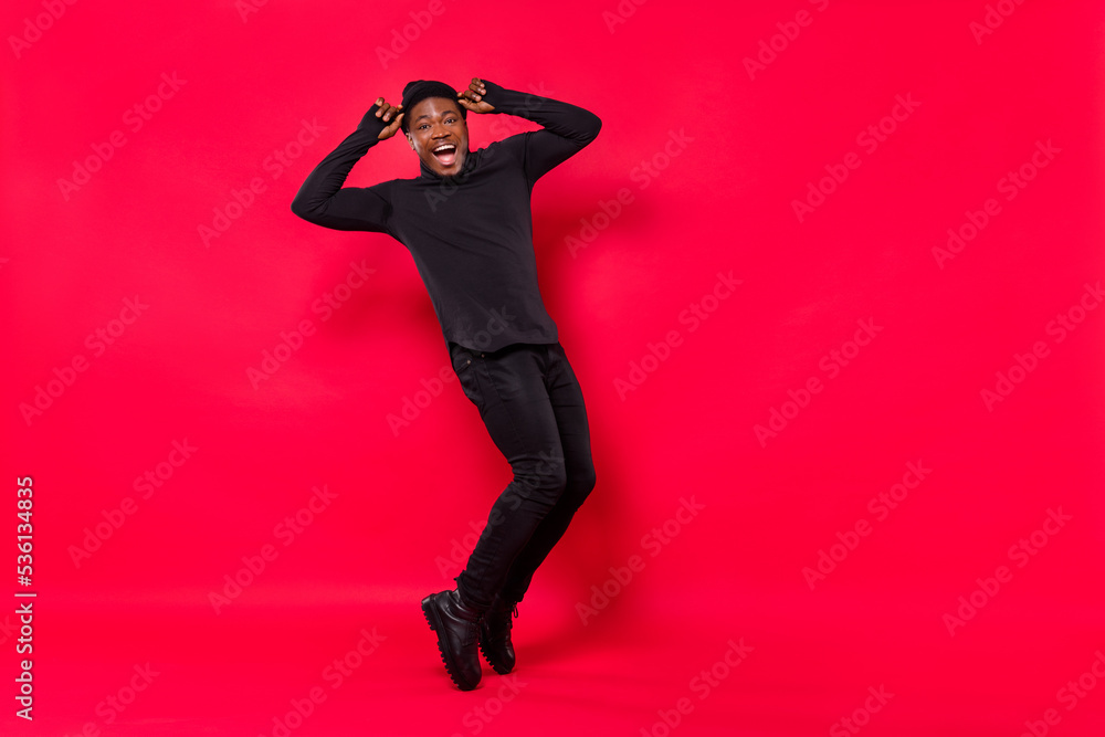 Full length body size view of attractive cheerful funny guy moving having fun good mood isolated over bright red color background Full length body size view of attractive cheerful funny guy moving having fun good mood isolated over bright red color background