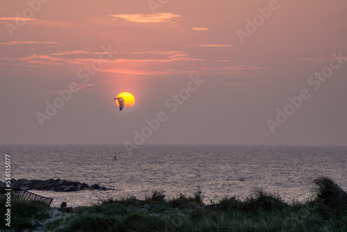 A kiter in front of a scenic sunset