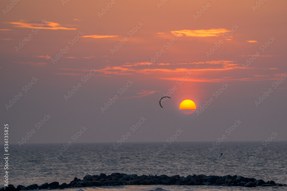 A kiter in front of a scenic sunset