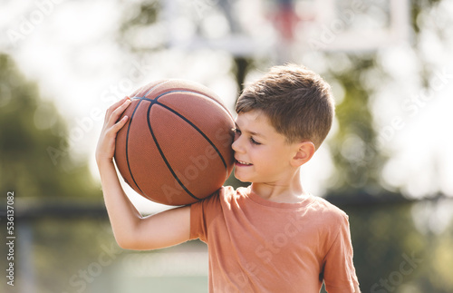 portrait of a boy kid playing with a basketball in park © Louis-Photo