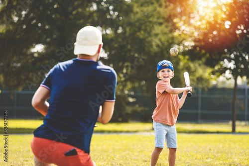 Wall Mural Father and son playing baseball in sunny day at public park