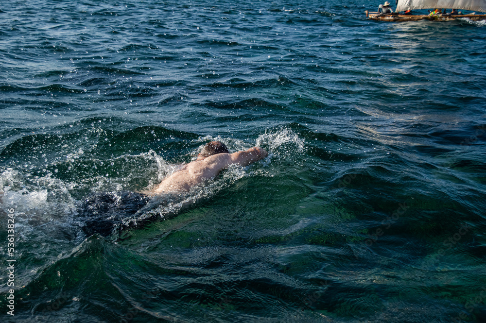 Naklejka premium White man swimming in the ocean on vacation