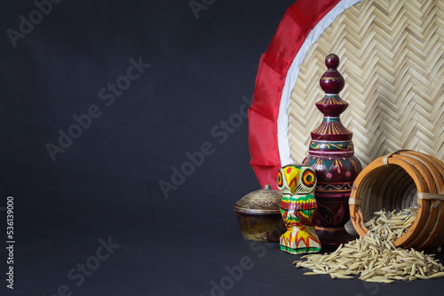 Laxmi puja essentials for rituals kept together. rice paddy grains  wooden owl and other objects symbolizing goddess of riches and prosperity during laxmi puja or makar sankranti in west bengal.