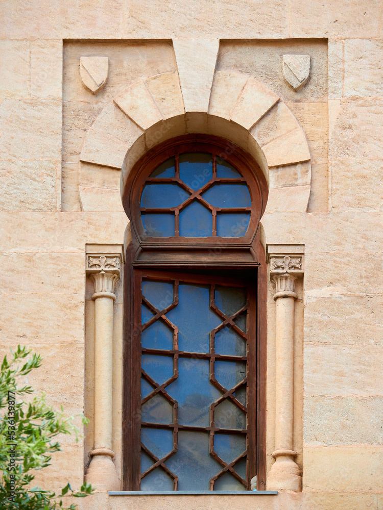 Fototapeta premium Horseshoe shaped window in stone wall