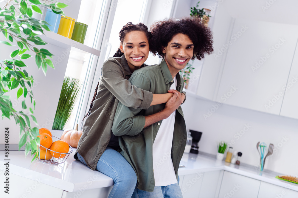 Photo of charming cheerful couple spend time together in kitchen room girlfriend hug her boyfriend behind feel comfy Photo of charming cheerful couple spend time together in kitchen room girlfriend hug her boyfriend behind feel comfy