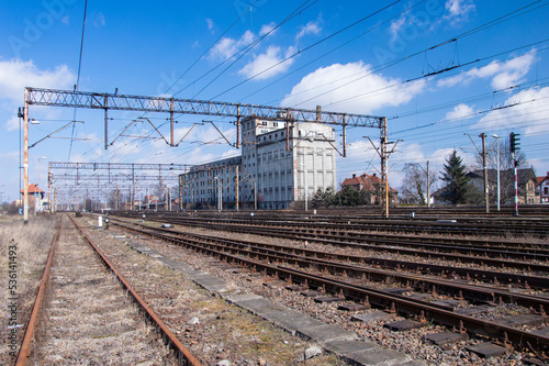 Railway infrastructure, tracks, rails and power cables over the tracks. Day.