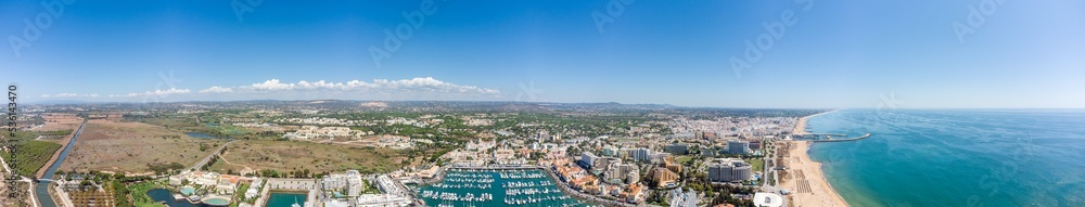Sensational panorama of beautiful Vilamoura city. Luxury hotels, yachts docked in the port. Famous travel destination in south of Portugal - Algarve region. View of the city and the port area