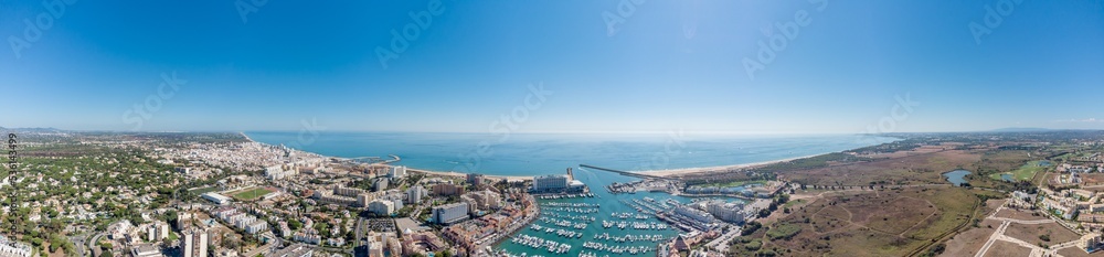 Sensational panorama of beautiful Vilamoura city. Luxury hotels, yachts docked in the port. Famous travel destination in south of Portugal - Algarve region. View of the city and the port area