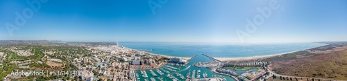 Sensational panorama of beautiful Vilamoura city. Luxury hotels, yachts docked in the port. Famous travel destination in south of Portugal - Algarve region. View of the city and the port area © alexemarcel