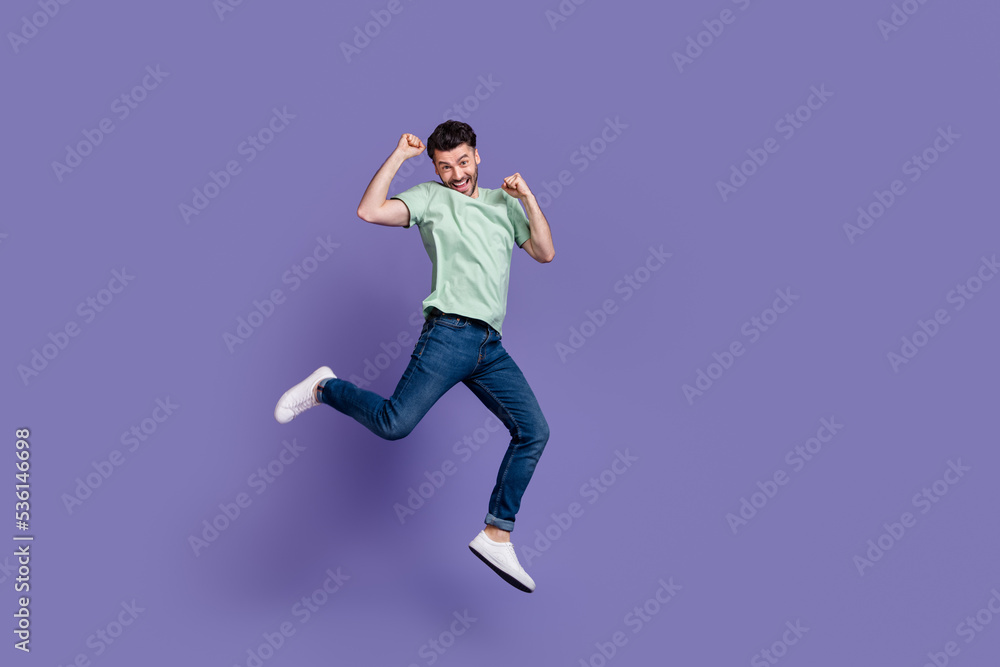 Full length photo of overjoyed stylish man fan rejoice win favorite football team hand fist empty space isolated on purple color background