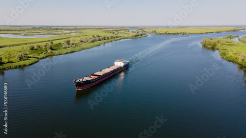 Grain carrier in the sea goes along the Dnieper. Delivery of wheat worldwide. Ship logistics in Ukraine.