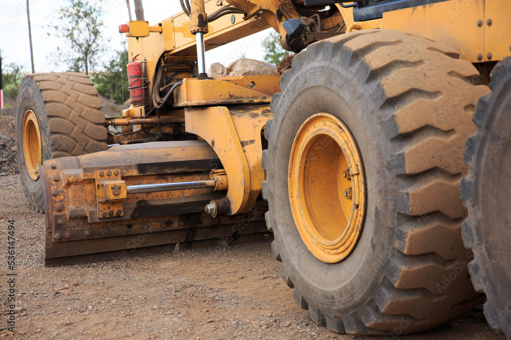 The process of repairing or building a road with a motor grader. The blade of the motor grader is a part of the machine. The process of repairing or building a road with a motor grader. The blade of the motor grader is a part of the machine.