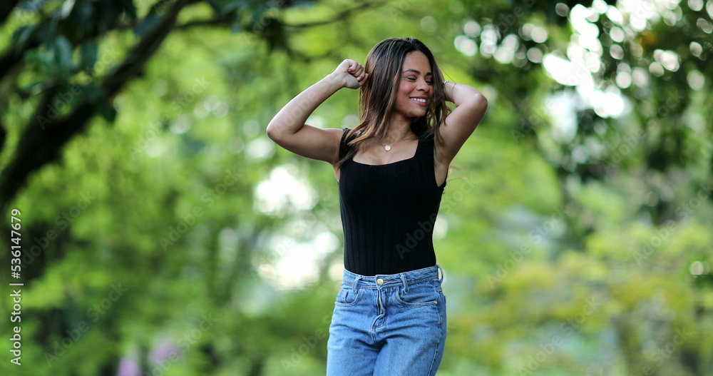 Happy girl celebrating success achievement, woman raising arms in air in victory stance Happy girl celebrating success achievement, woman raising arms in air in victory stance