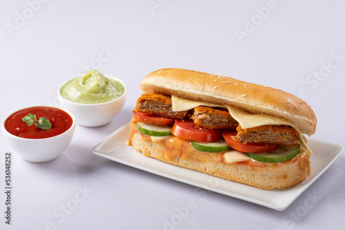 Fresh submarine sandwiches with ham, cheese, bacon, tomatoes, lettuce, cucumbers and onions on White background.