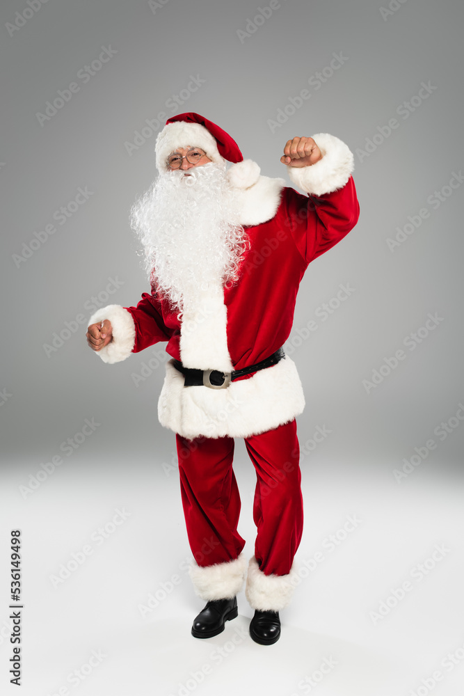 Full length of barded santa claus dancing and looking at camera on grey background. Full length of barded santa claus dancing and looking at camera on grey background.
