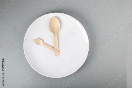 wooden spoons on white plate like indicators on gray background flat lay