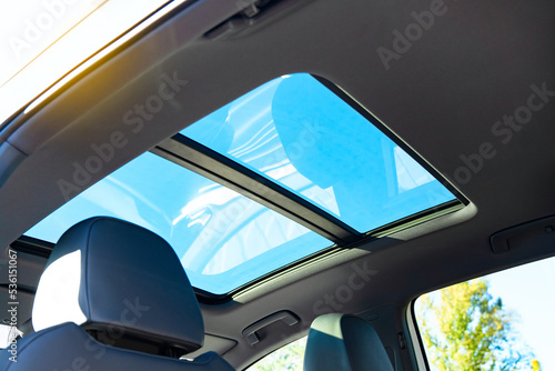 Automobile panoramic glass roof in a modern car. Blue sky view. photo