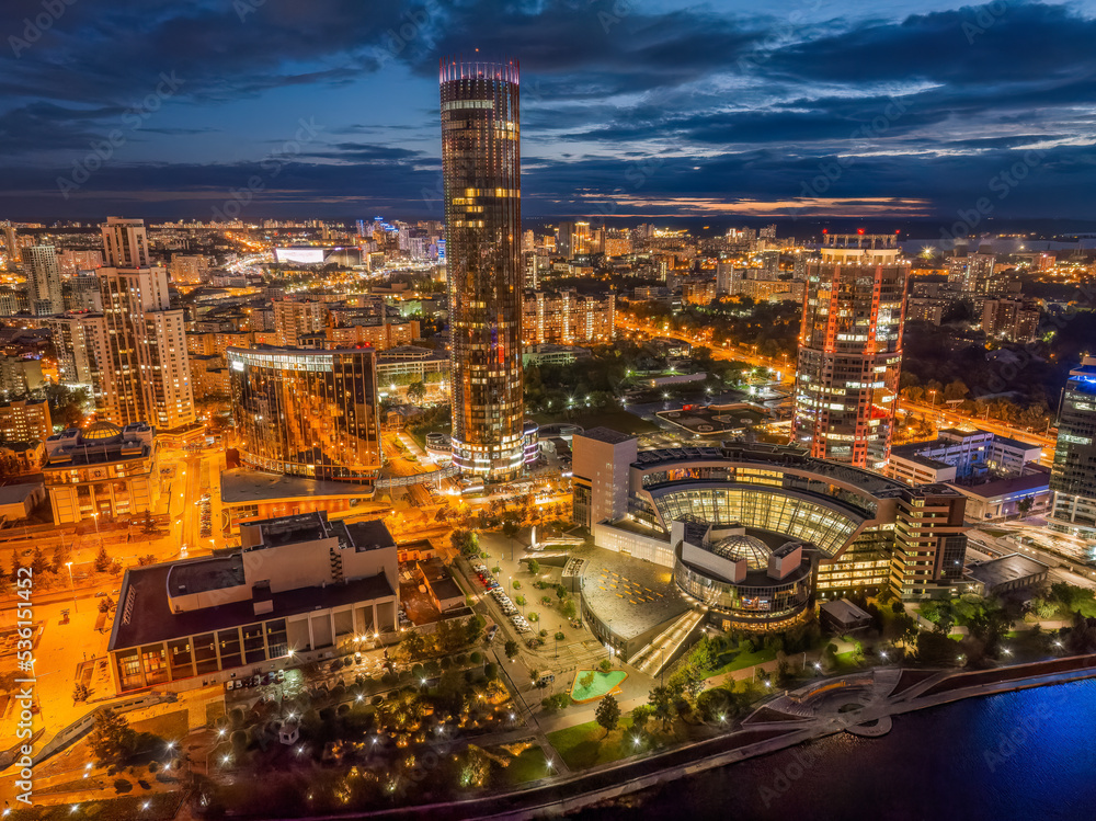 Fototapeta premium Yekaterinburg city and pond aerial panoramic view at summer or early autumn night. Night city in the early autumn or summer.