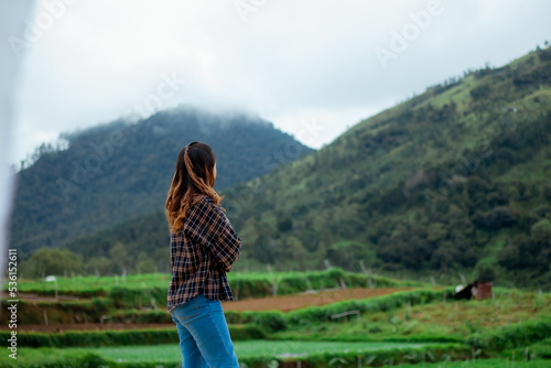 Asian woman taking pictures, vacationing, relaxing, enjoying the air, enjoying the day off by traveling to nature. enjoy a vacation in nature. © ajiilhampratama