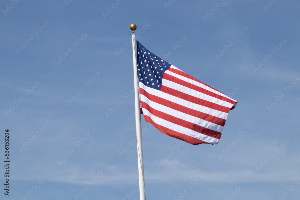 American flag waving in the wind with a blue sky