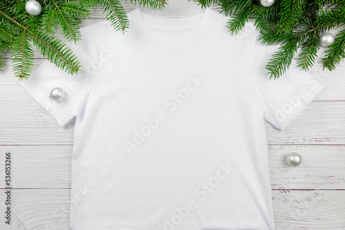 White womens cotton tshirt mockup with christmas tree branches and decoration. Design t shirt template, print presentation flat lay mock up. photo