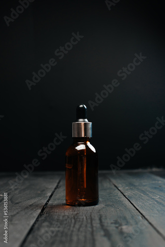 brown essential bottle on dark background